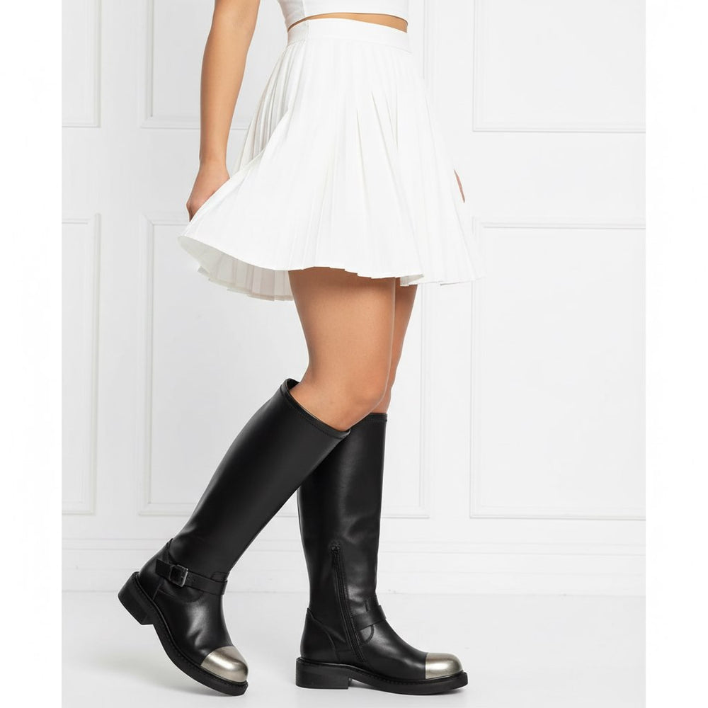 Women wearing black long boots with metal toe and buckle strap detail