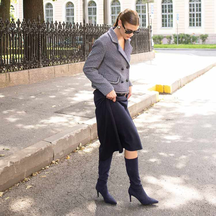 Woman in a gray jacket and navy skirt