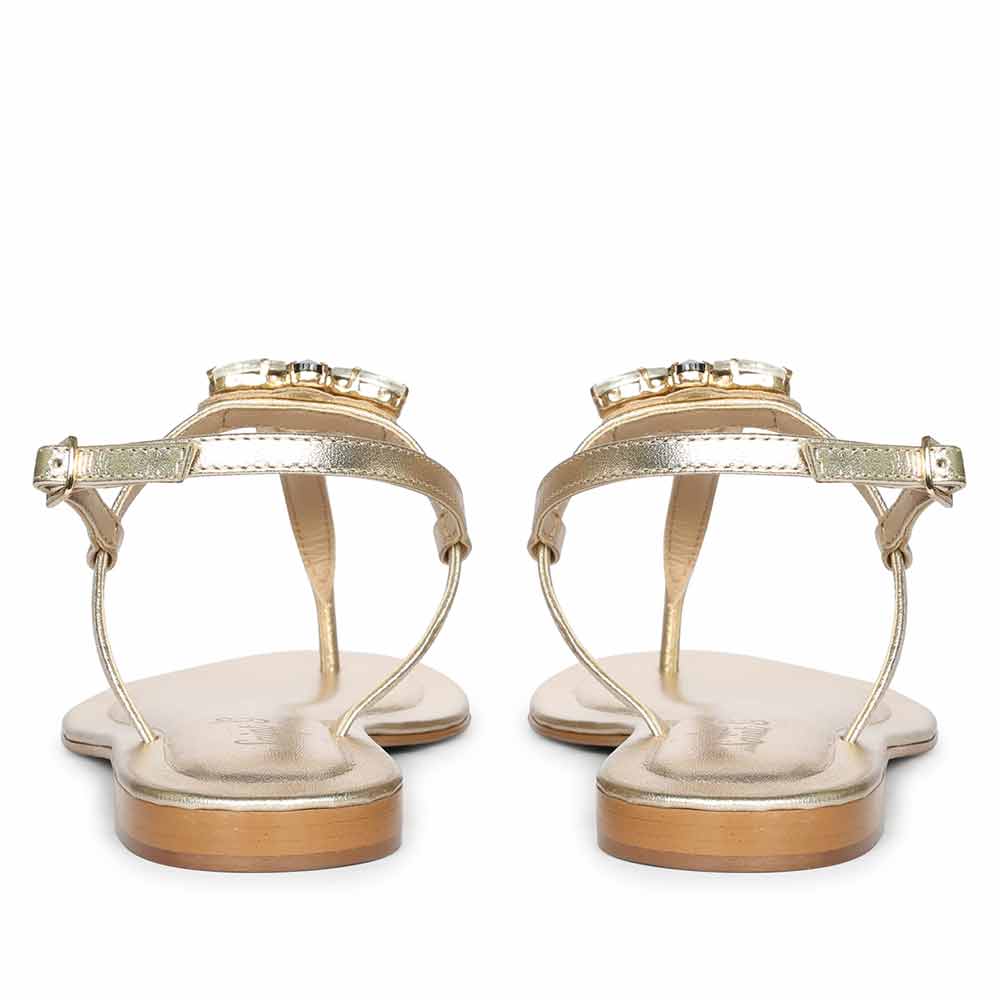 Rear view of platin leather sandals with adjustable ankle strap and gold pin buckle closure