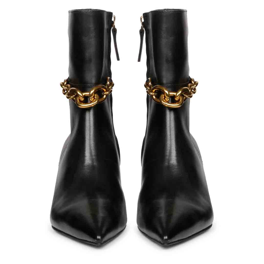 Front view of black pointed-toe ankle boots with gold chain accents at the ankle