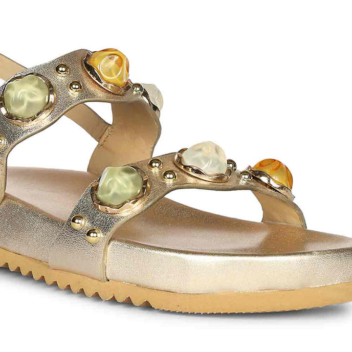 Gold sandal with gemstone embellishments on a white background | Close up view