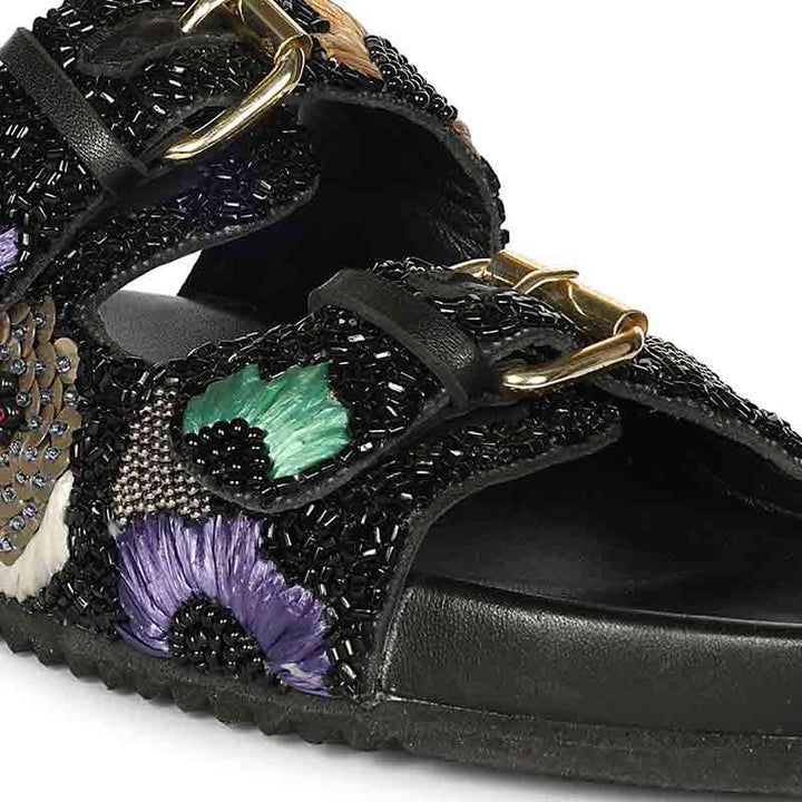 Black embellished sandal with floral details on a white background