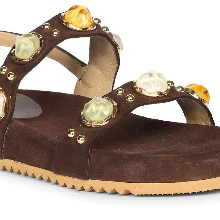 Brown sandal with decorative gemstones on a white background