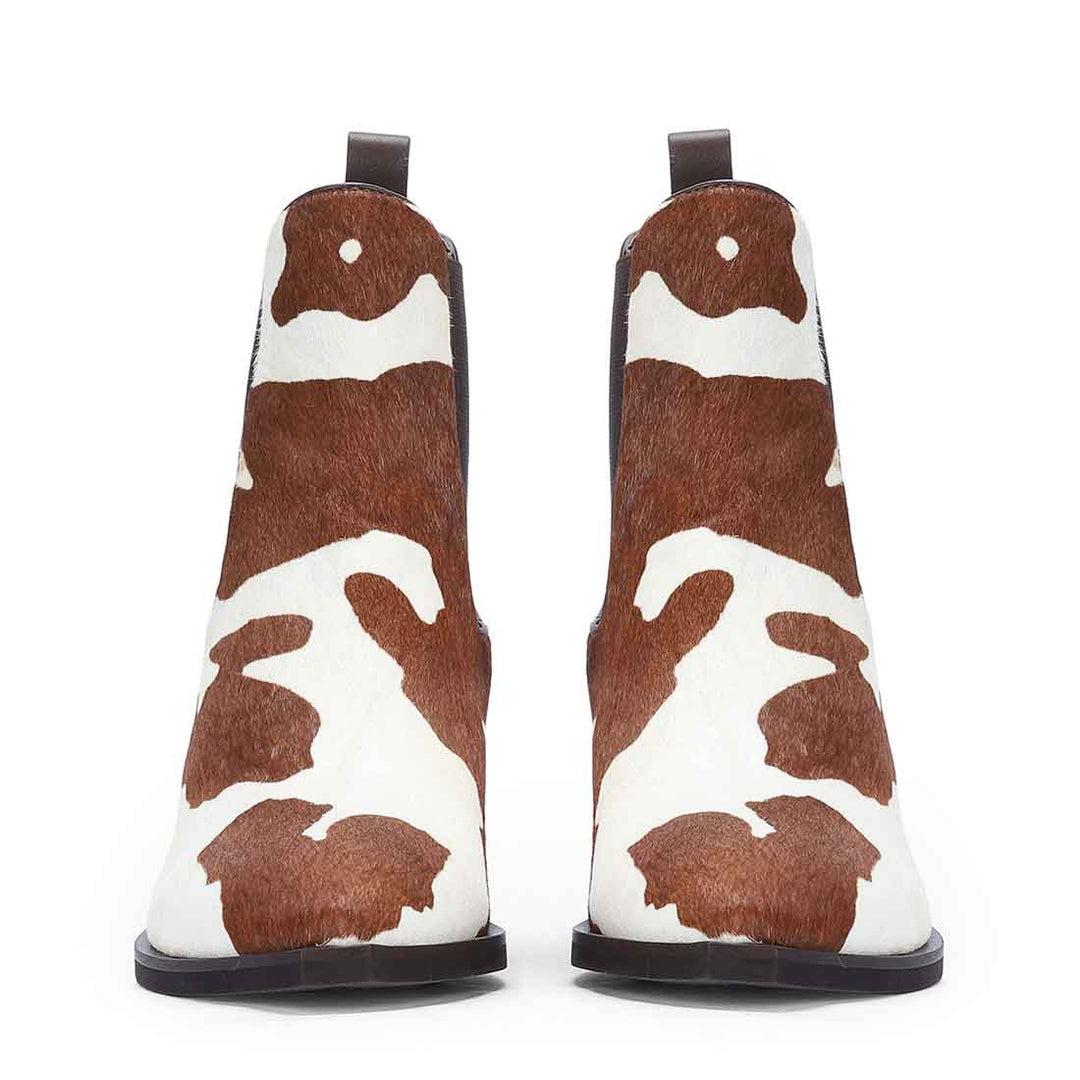 Front view of brown and white pony hair ankle boots with pull tabs and stacked heels