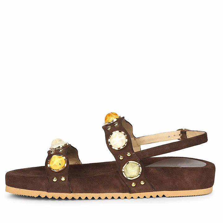 Brown sandal with gold embellishments on a white background