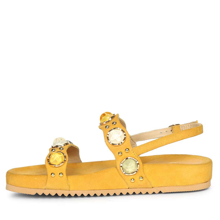 Yellow sandal with decorative elements on a white background