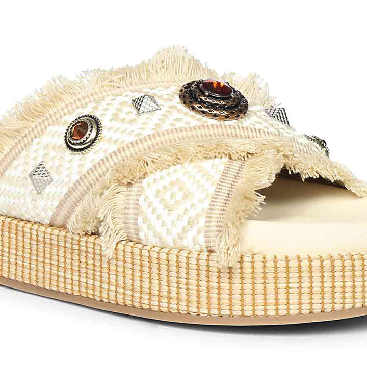Beige sandal with decorative elements on a white background