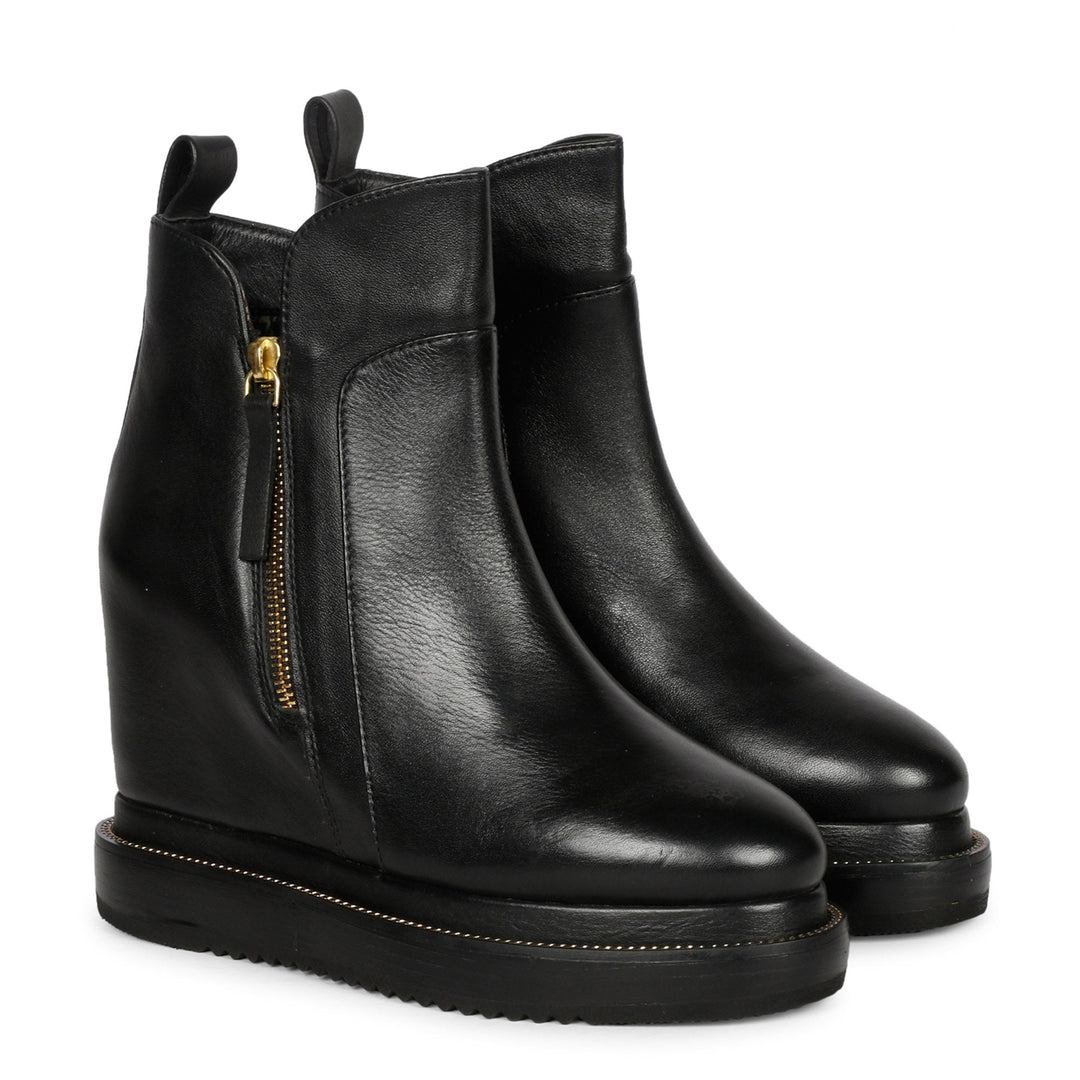 Black leather wedge ankle boots for women with gold zip, angled view