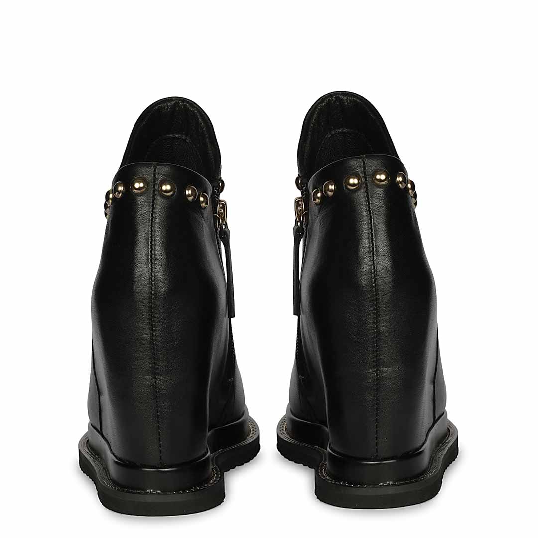 Pair of black studded leather wedge ankle boots for women,  back views