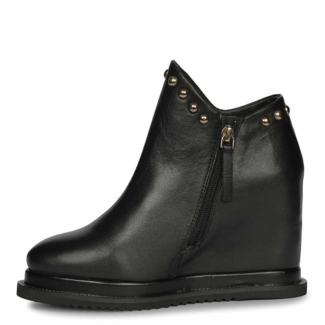 Black studded leather wedge ankle boots for women with high inside wedge, side profile