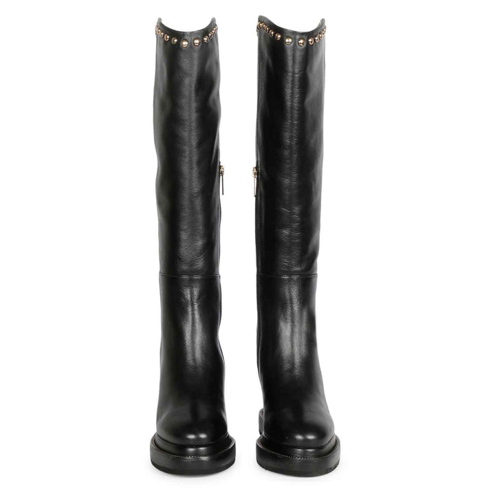 Pair of womens black studded leather wedge long boots, front view