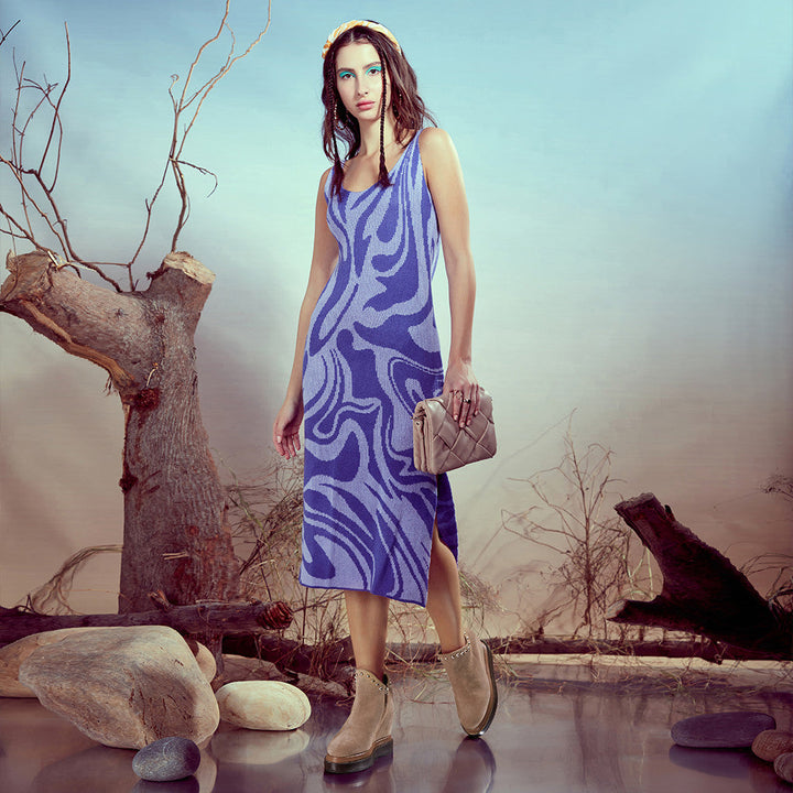 Model wearing ladies beige suede wedge ankle boots with a blue dress