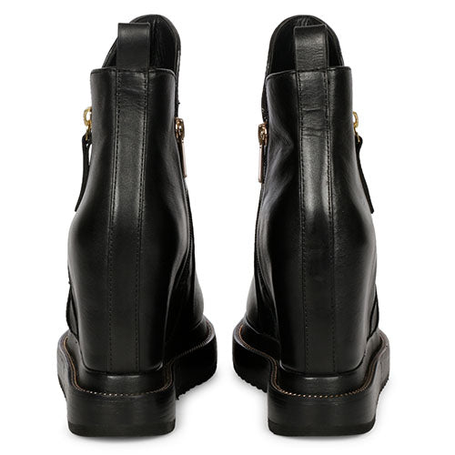 Pair of ladies black leather wedge ankle boots, back view