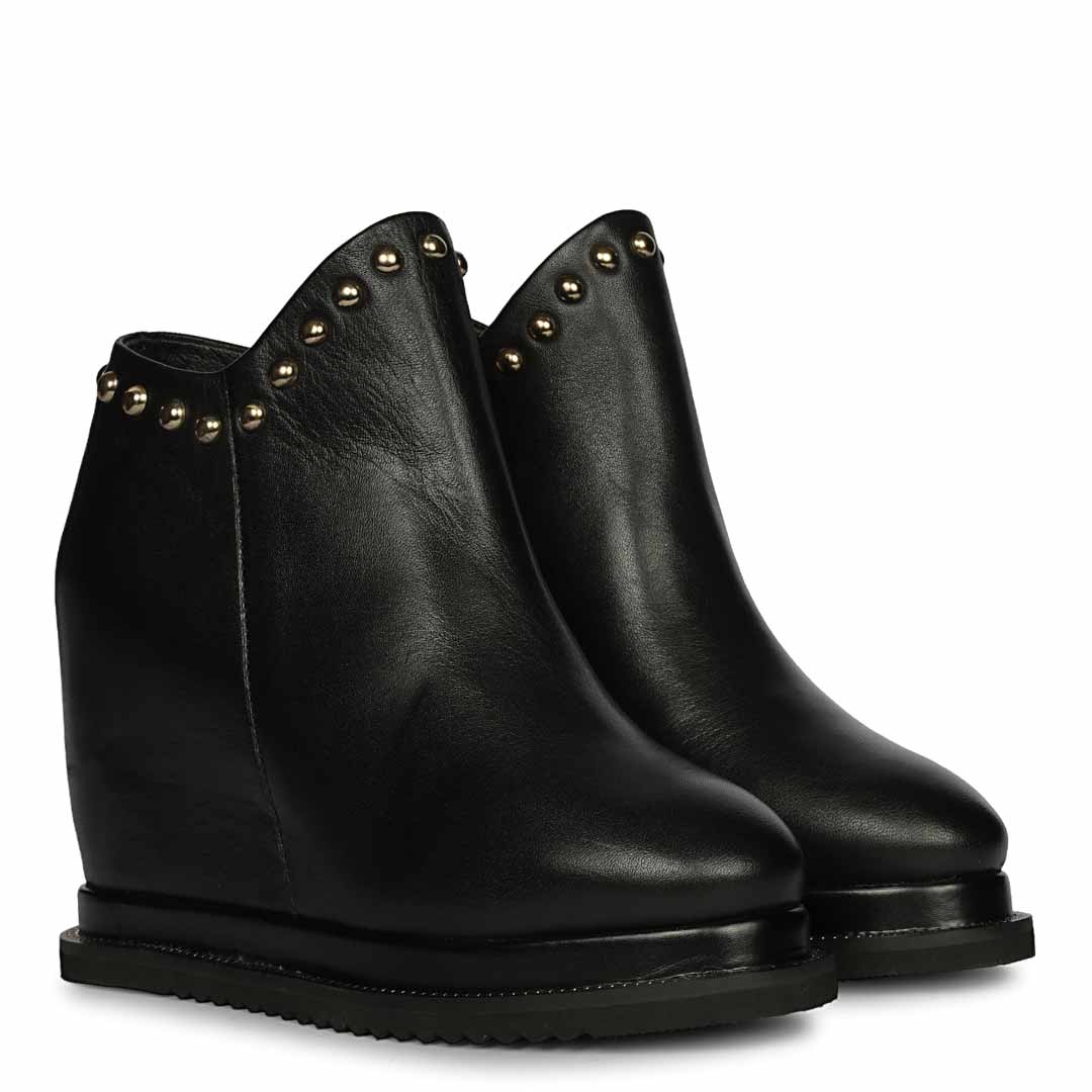 Pair of ladies black studded leather wedge ankle boots, angled view