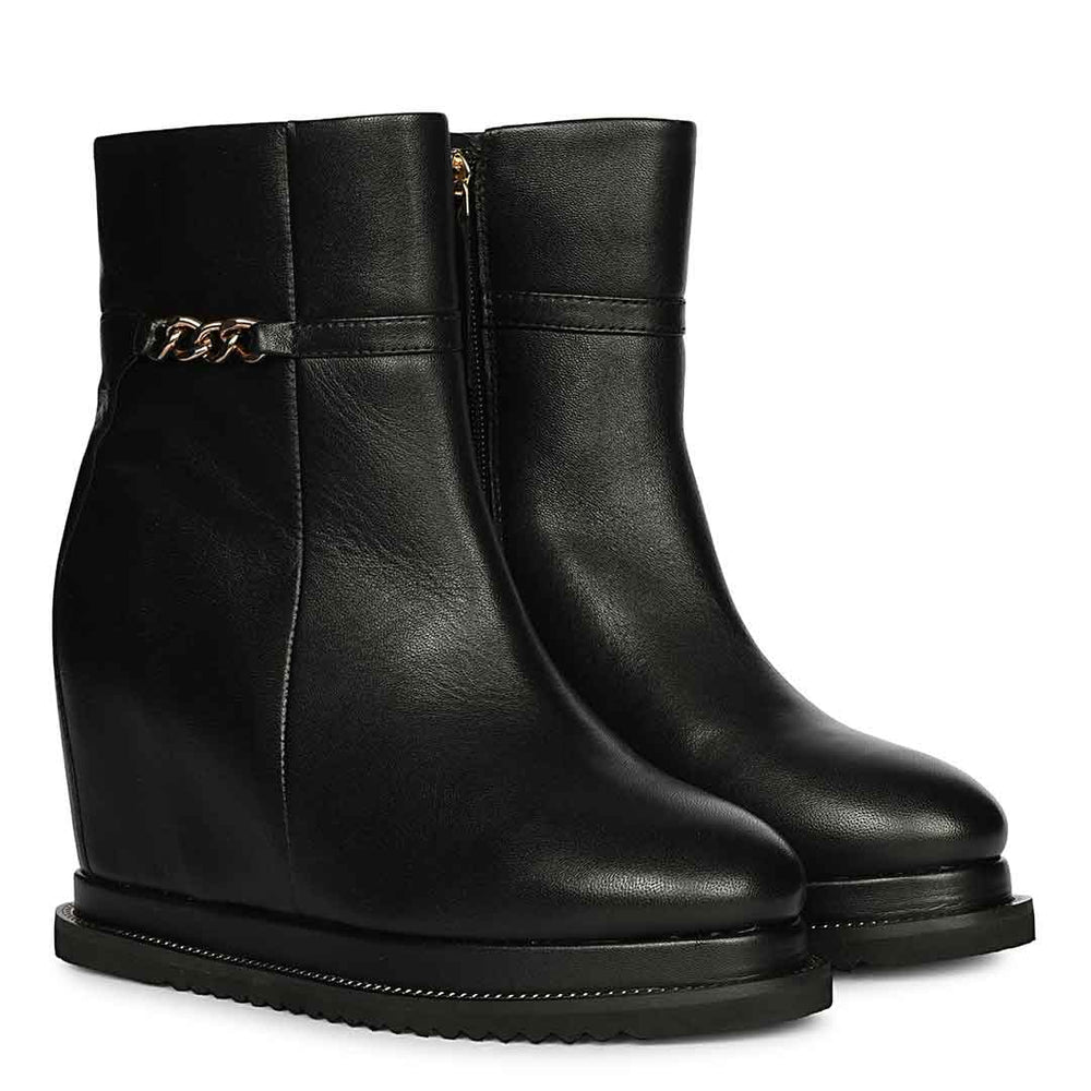 Ladies black leather wedge ankle boots with front chain detail, angled view