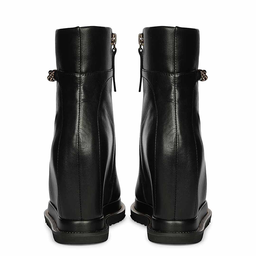 Pair of ladies black leather wedge ankle boots, back view