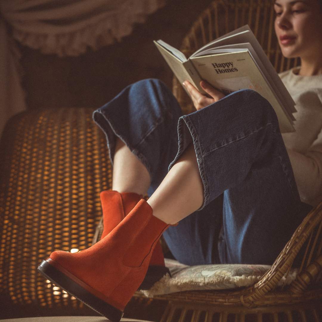 Model wearing ladies coral suede wedge ankle boots in a styled setting