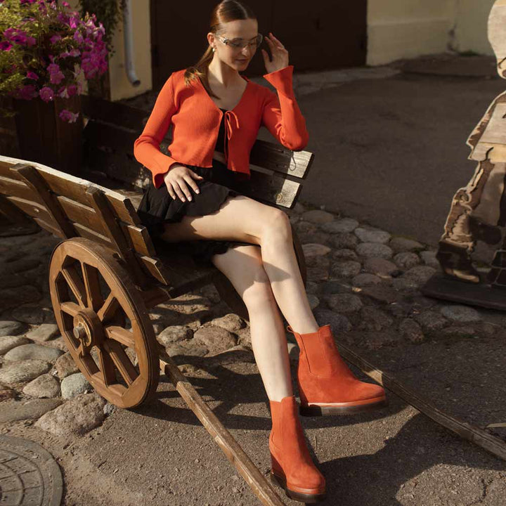 Model wearing ladies coral suede wedge ankle boots, styled look