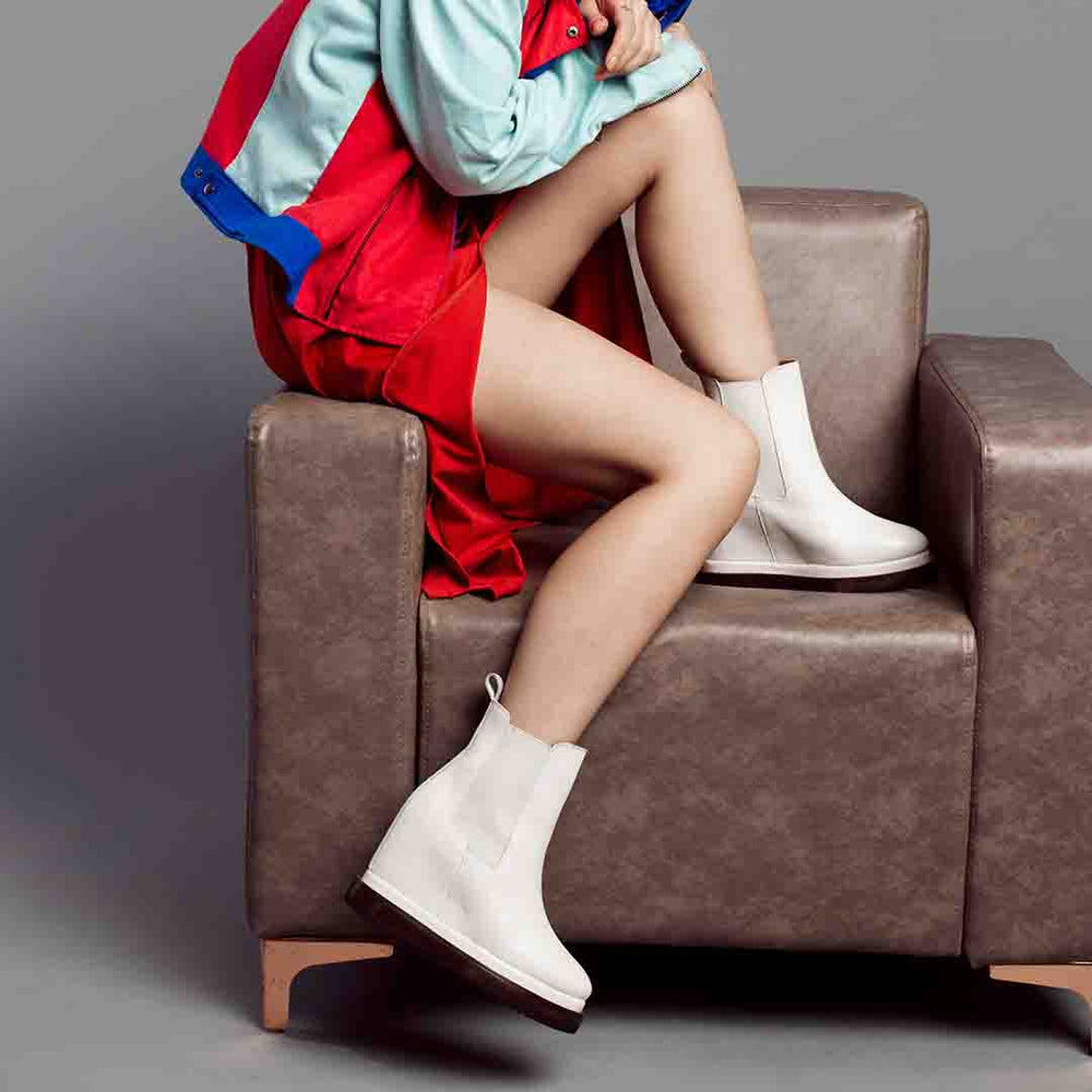 Model wearing ladies off-white wedge ankle boots, styled outfit
