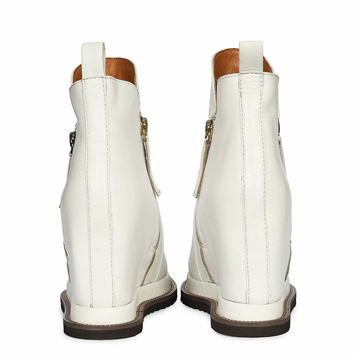 Pair of ladies white leather wedge ankle boots, back angled view