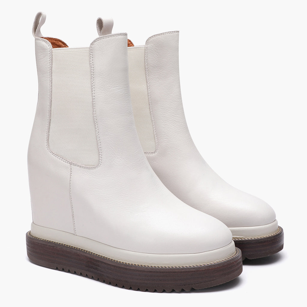 Off-white leather wedge ankle boots for women with elastic side panel, angled view