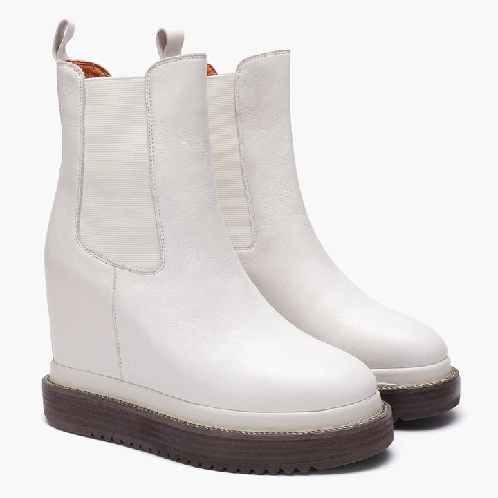 Off-white leather wedge ankle boots for women with elastic side panel, angled view