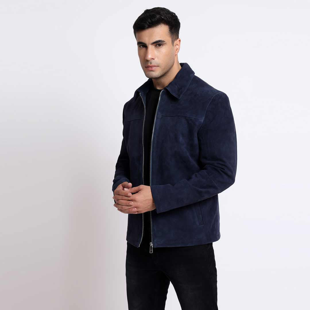 Man wearing an open navy suede jacket with a shirt collar.