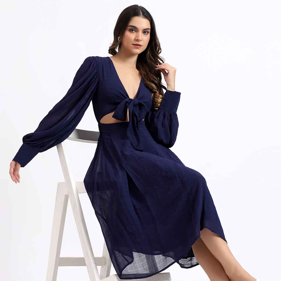 Women's navy cutout midi dress by Saint Aurora, seated lifestyle view.