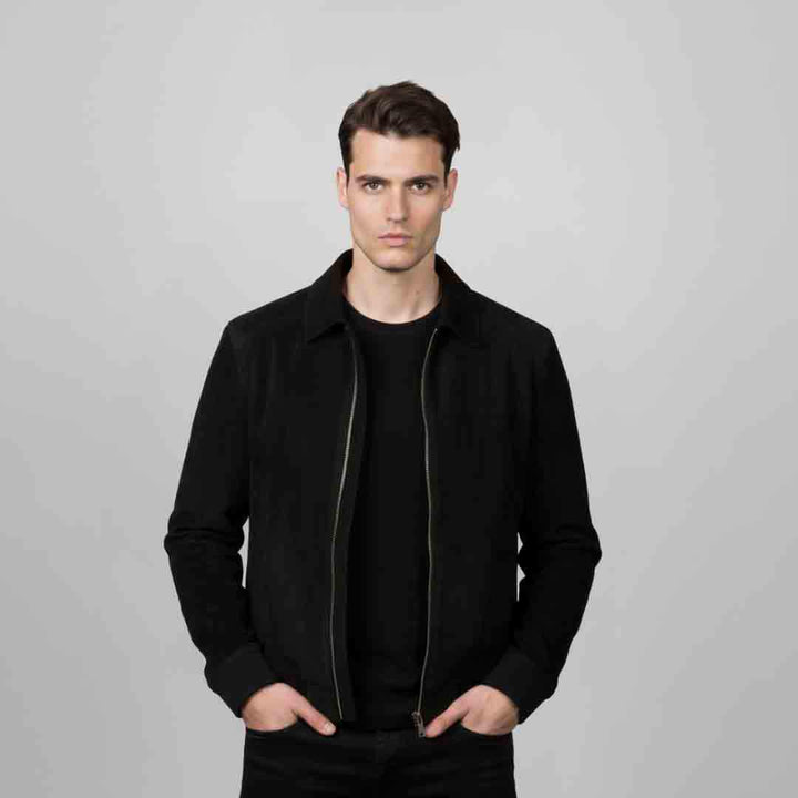 Man wearing an open black bomber jacket with fur trim.