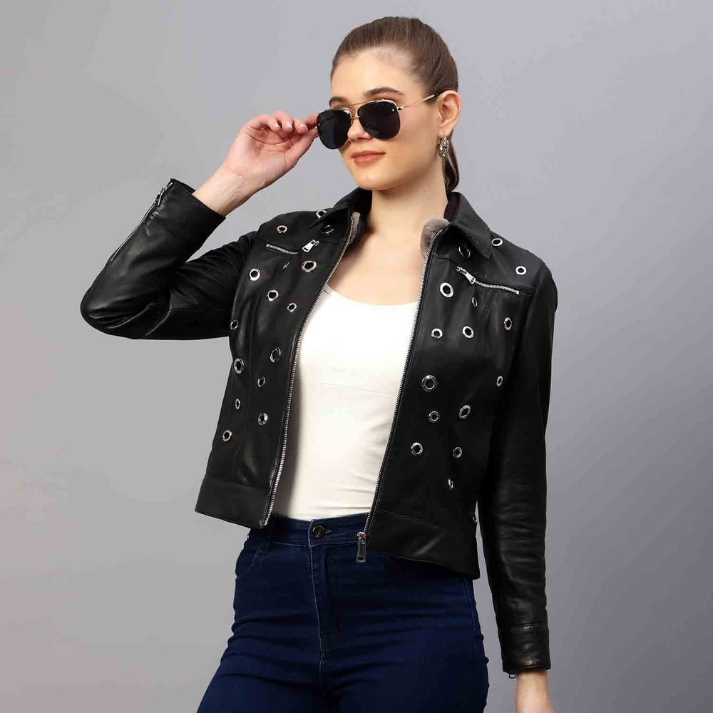 Women's black leather eyelet jacket UK by Saint Bryony, styled seated lifestyle shot