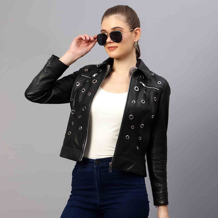 Women's black leather eyelet jacket UK by Saint Bryony, styled seated lifestyle shot