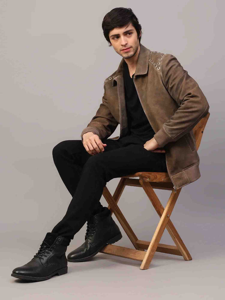 Man wearing an open distressed brown suede jacket with grommet hardware.