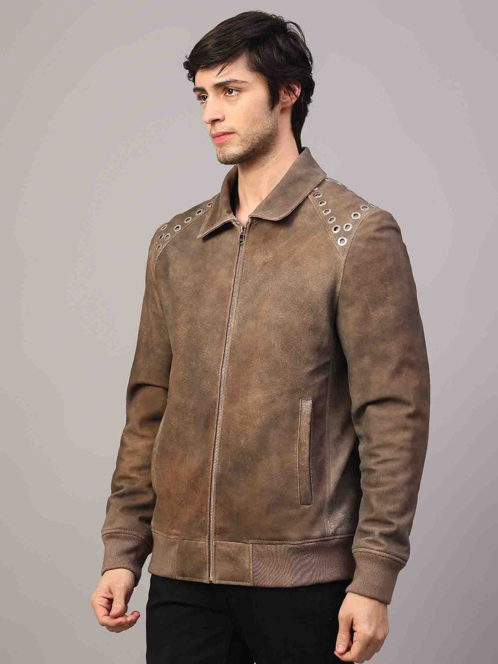 Man wearing a zipped-up distressed brown suede jacket with grommet hardware.