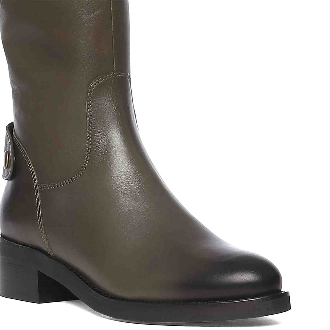 Close-up of button tab strap detail on Saint Chloe olive leather knee high boots