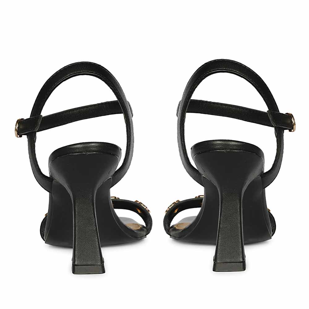 Black high-heeled shoes with thin straps on a white background, back view