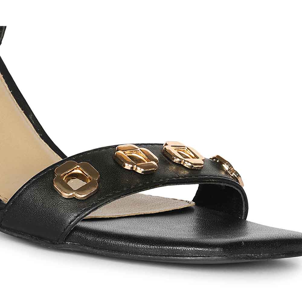 Close-up of gold flower eyelet detail on Saint Dahlia black leather heels