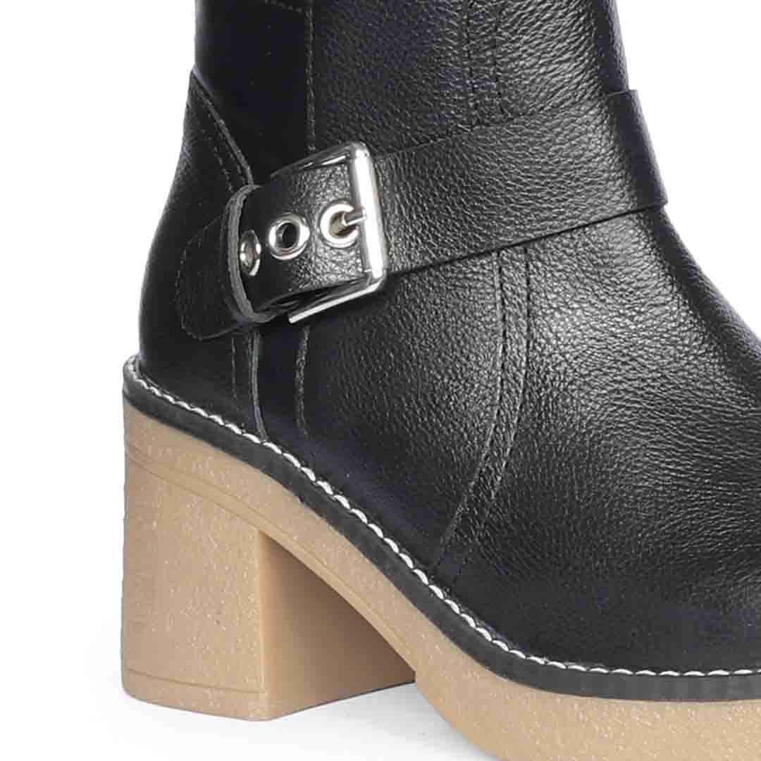 Close-up of silver buckle strap and chunky heel on Saint Dahlia black leather long boots