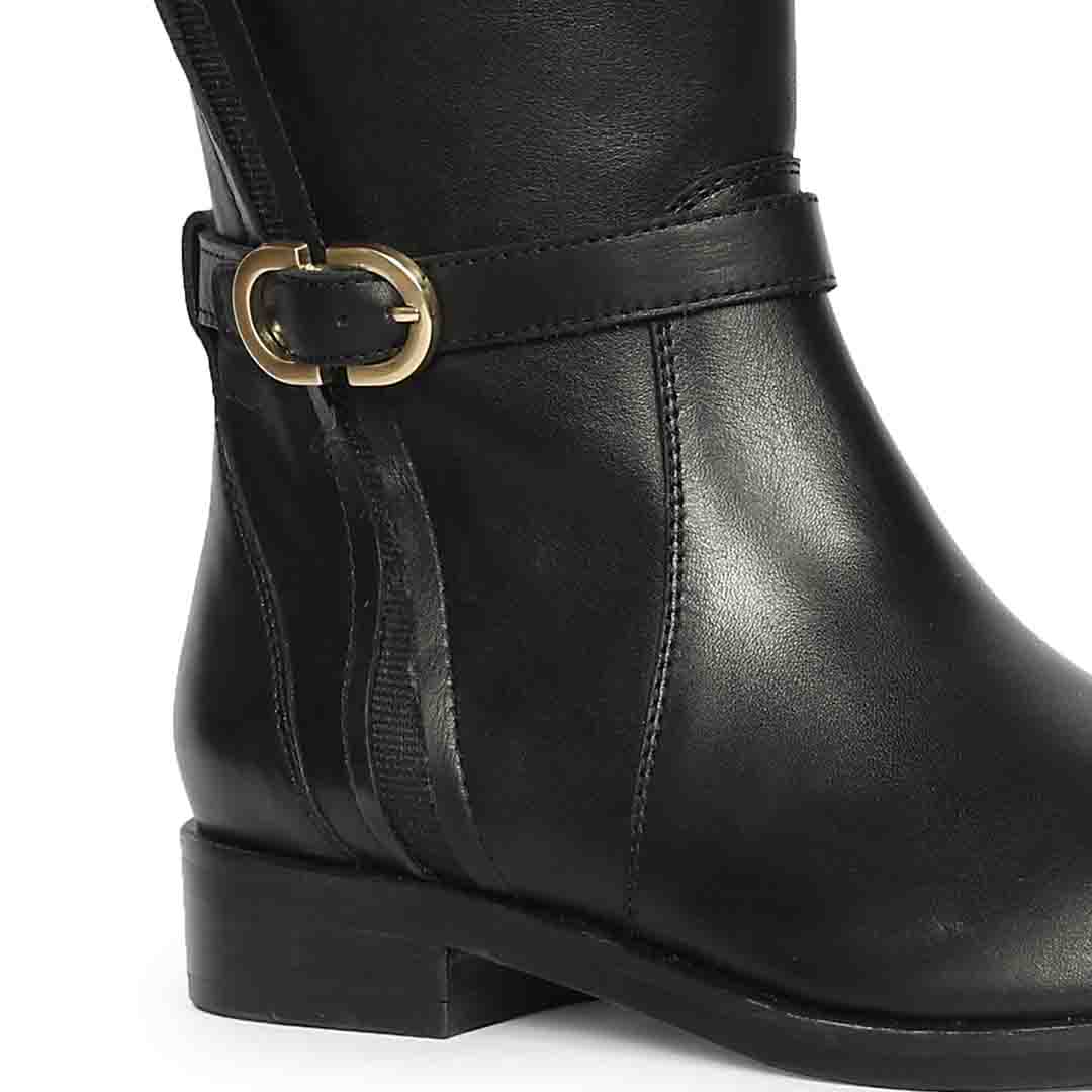 Close-up of gold buckle strap on Saint Darla dual gold buckle black leather long boots