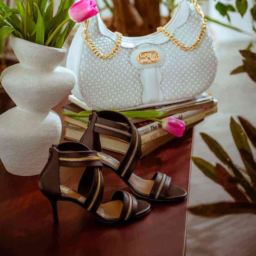 Saint Delilah black leather stiletto sandals styled with SaintG UK handbag, lifestyle shot