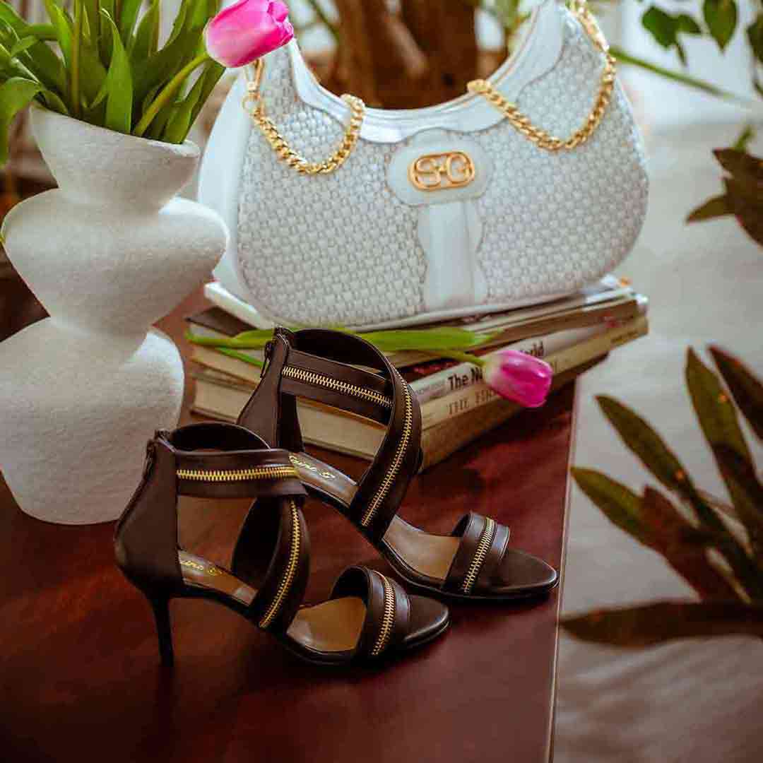 Saint Delilah black leather stiletto sandals styled with SaintG UK handbag, lifestyle shot
