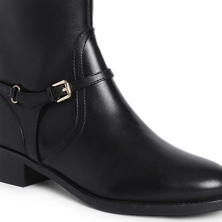 Close-up of buckle strap detail on Saint Drusilla black leather knee high boots