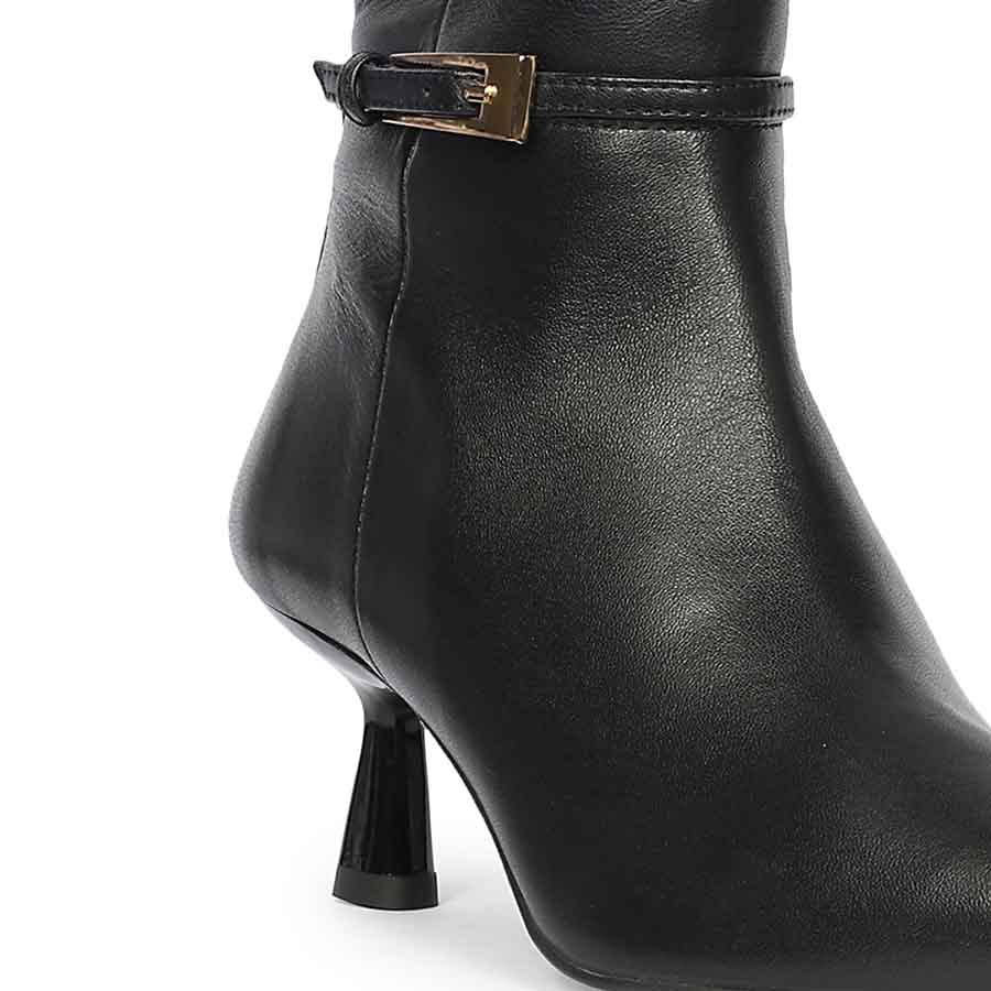 Close-up of gold buckle strap and flared kitten heel on Saint Elara black leather long boots