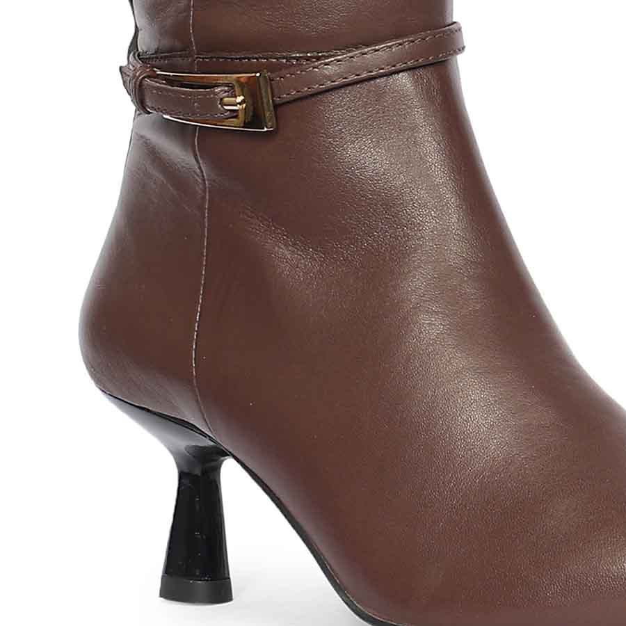 Close-up of gold buckle strap and flared kitten heel on Saint Elara brown leather long boots