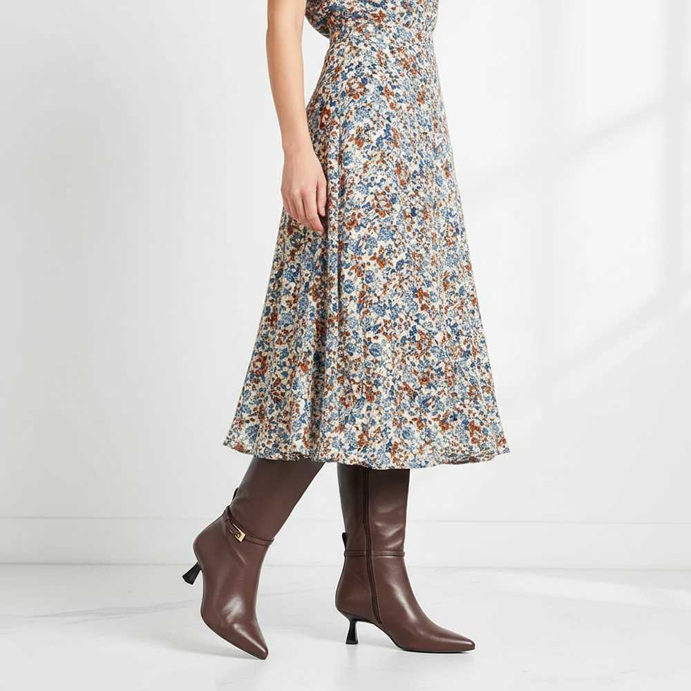 Women's Saint Elara brown leather long boots styled with a floral midi dress, lifestyle view