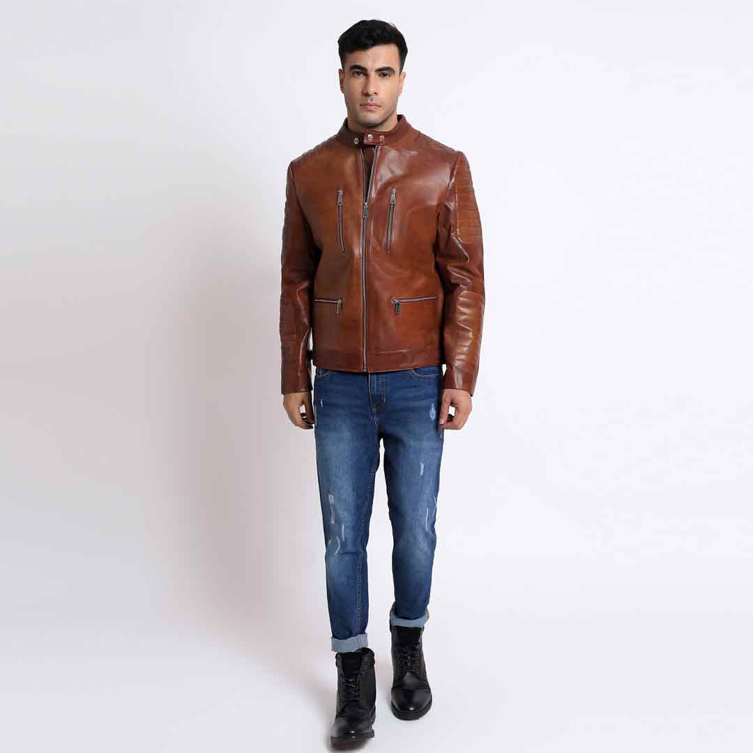 Full-length shot of a man wearing a tan/cognac brown leather cafe racer jacket.