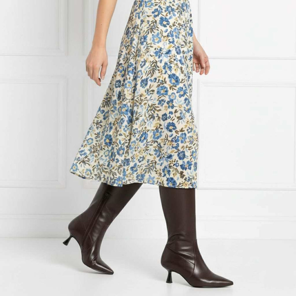 Women's Saint Emilia brown knee high boots styled with a floral midi skirt, lifestyle view