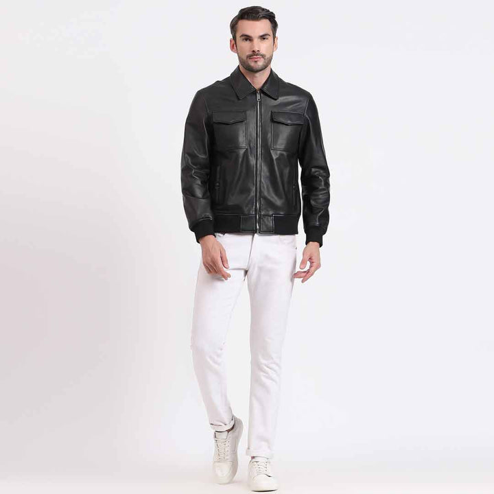 Full-length shot of a man wearing a black leather bomber-style jacket.