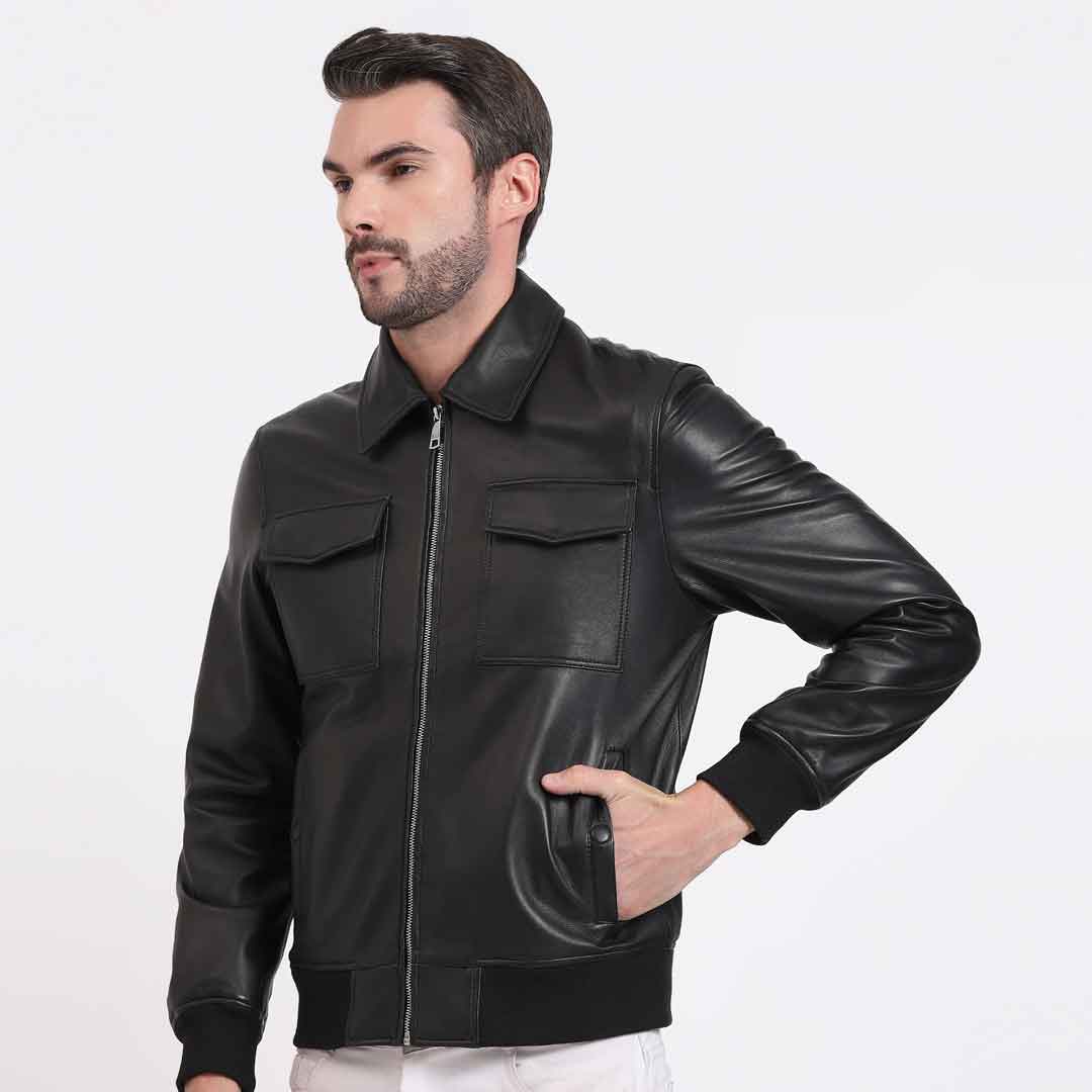 Side view of a man wearing a black leather bomber-style jacket.