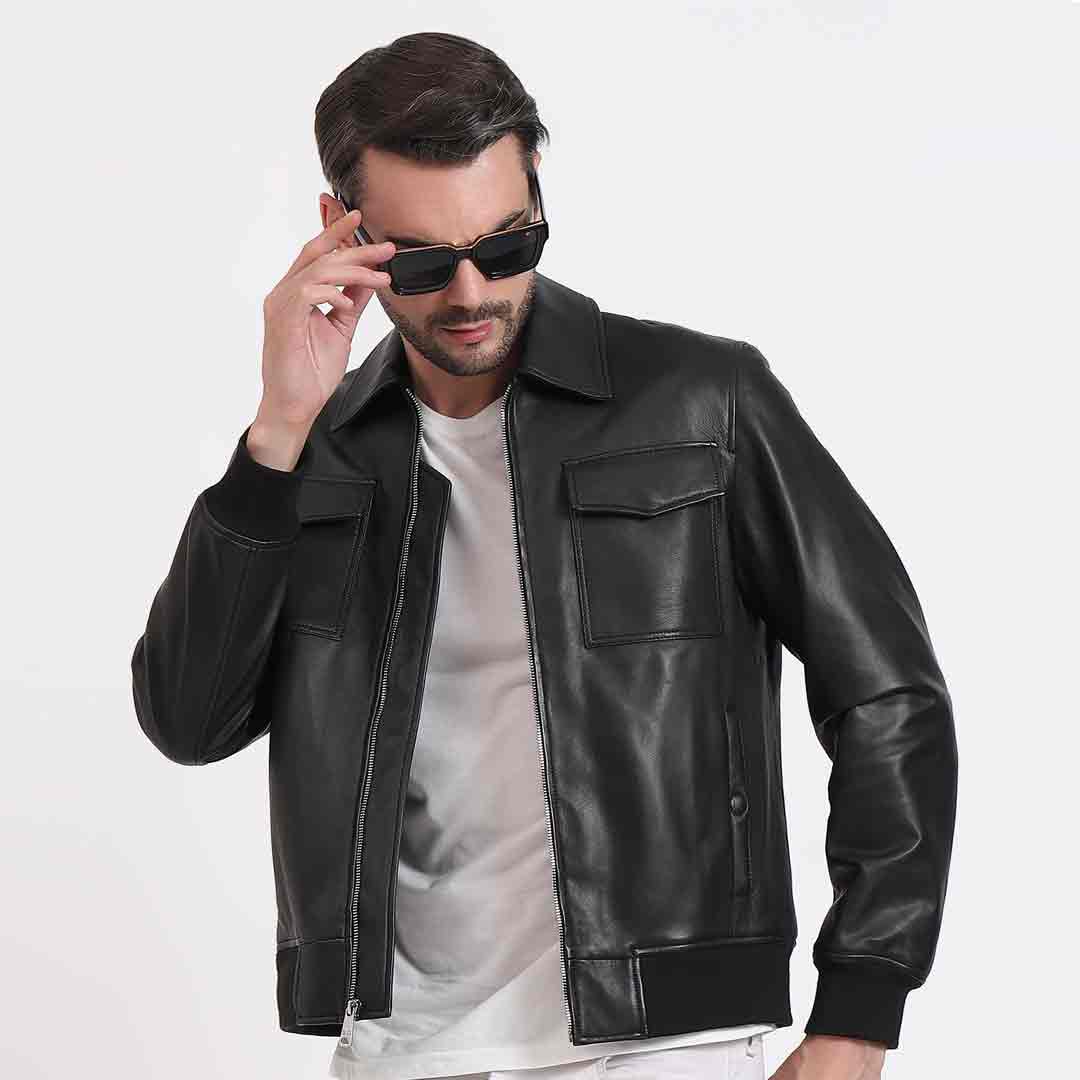 Man wearing a zipped-up black leather bomber-style jacket.