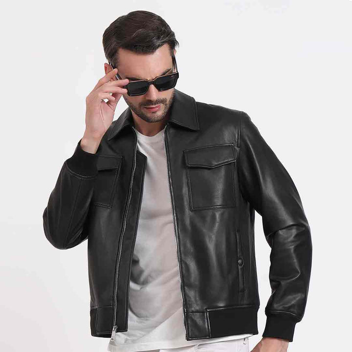 Man wearing a zipped-up black leather bomber-style jacket.